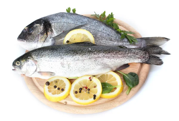 Färska fiskar med citron, persilja och krydda på trä skärbräda isolerad på vit — Stockfoto
