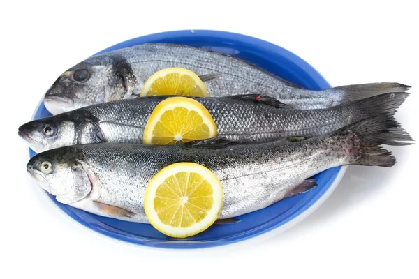 Fresh fishes with lemon on plate isolated on white — Stock Photo, Image