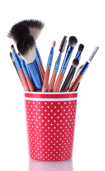 Pinceles de maquillaje en taza roja aislados en blanco — Foto de Stock