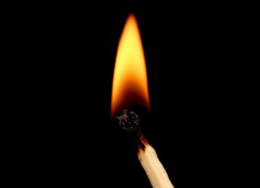 Burning match on black background clipart