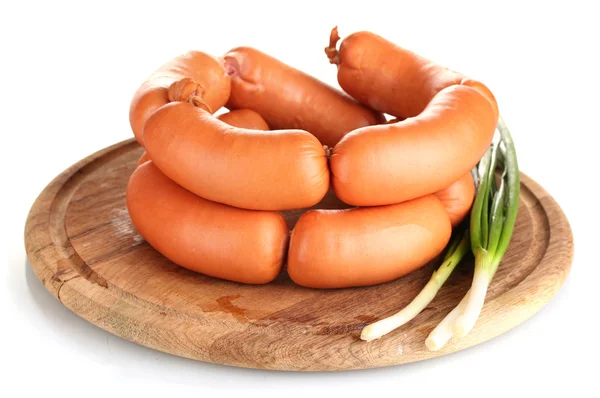 Tasty sausages on wooden board and green onion isolation on white — Stock Photo, Image