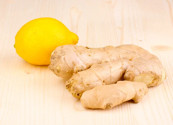 Ginger with lemon on wooden background — Stock Photo, Image
