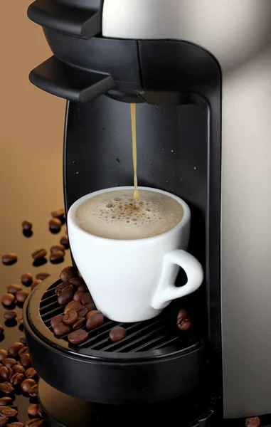 Stock image Espresso machine pouring coffee in cup on brown background