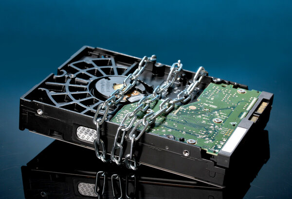 Hard disk drive on chain on dark blue background