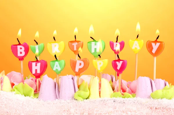 Verjaardagscake met kaarsen op gele achtergrond — Stockfoto
