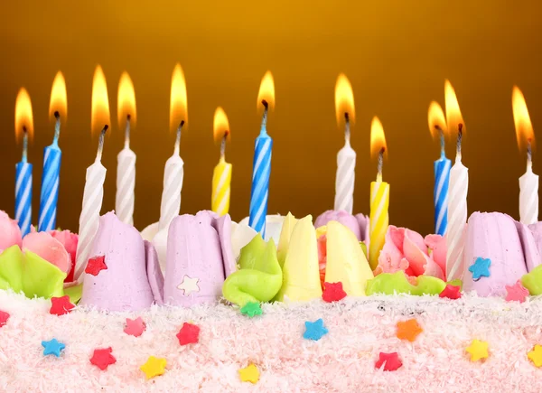 Narozeninový dort se svíčkami na hnědé pozadí — Stock fotografie