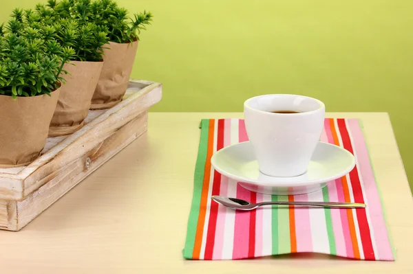 Koffiekopje op tafel in café op groene achtergrond — Stockfoto