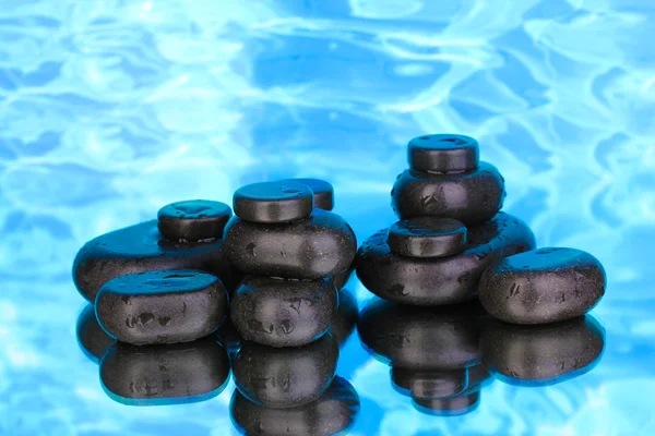 Курортные камни с капельками на синем фоне — стоковое фото