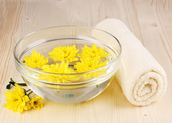 Bowl with yellow flowers, spa setting on wooden background — Stock Photo, Image