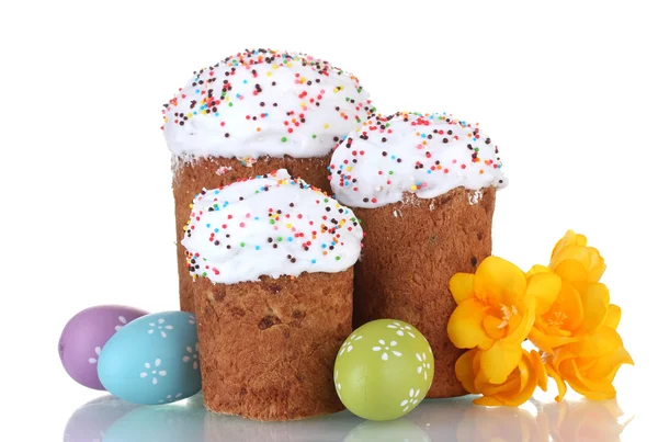 Mooie Pasen cakes, kleurrijke eieren en bloemen geïsoleerd op wit — Stockfoto