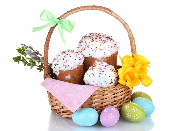 Piękne wielkanocne ciasta w kosz, kolorowe jajka i kwiaty na białym tle — Zdjęcie stockowe