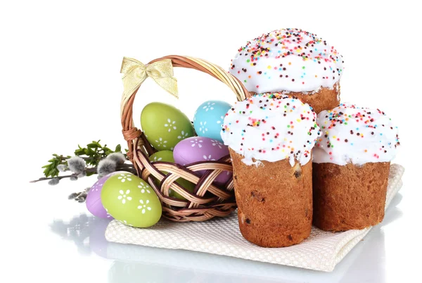 Красивые пасхальные торты, красочные яйца в корзине и цветы изолированы на белом — стоковое фото