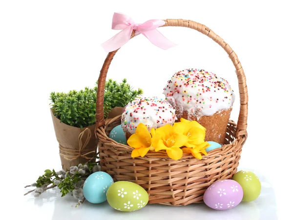 Hermosos pasteles de Pascua, huevos coloridos en cesta y flores aisladas en blanco — Foto de Stock