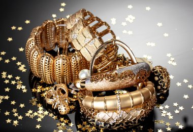 Beautiful golden jewelry on grey background clipart