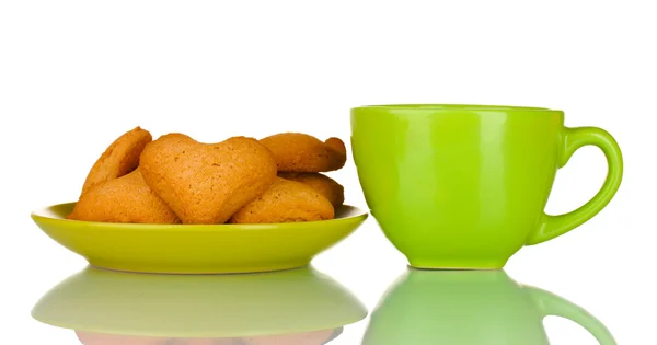 Grüne Tasse und herzförmige Kekse auf grünem Teller isoliert auf weißem Teller — Stockfoto