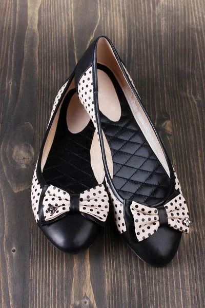 Sapatos de balé plano feminino modelado com bolinhas pretas em fundo de madeira — Fotografia de Stock
