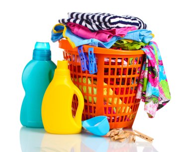 Clothes with detergent and washing powder in orange plastic basket isolated on white clipart