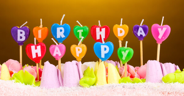 Birthday cake with candles on brown background