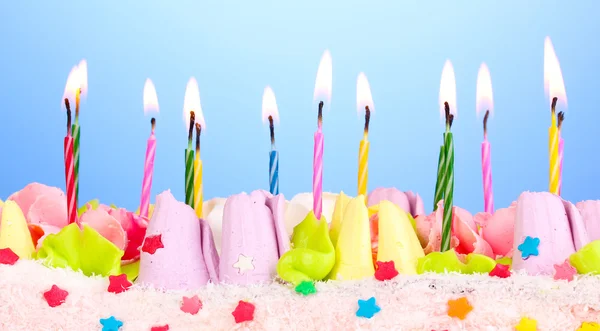 Geburtstagstorte mit Kerzen auf blauem Hintergrund — Stockfoto