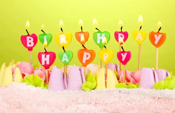 Verjaardagscake met kaarsen op groene achtergrond — Stockfoto