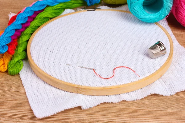 El aro de bordado con tela e hilos de coser brillantes para bordar en la mesa —  Fotos de Stock