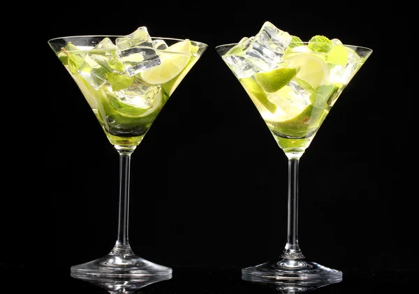 Glasses of cocktails with lime and mint on black background — Stock Photo, Image