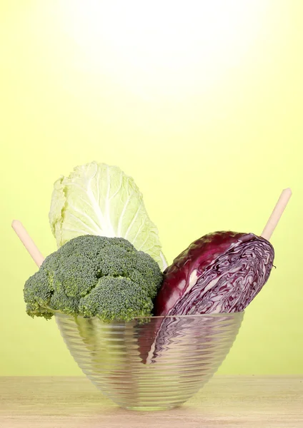 Lahana ve brokoli yeşil zemin üzerine ahşap masa üzerinde bir cam kase — Stok fotoğraf