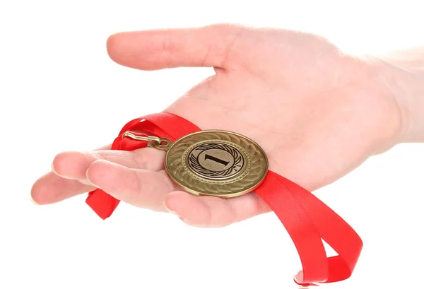 Gouden medaille in de hand geïsoleerd op wit — Stockfoto