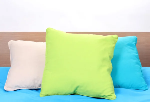 Bright pillows on bed on white background — Stockfoto