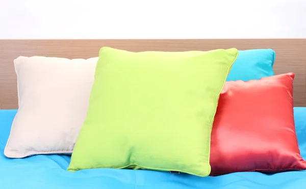 Яркие подушки на кровати на белом фоне — стоковое фото