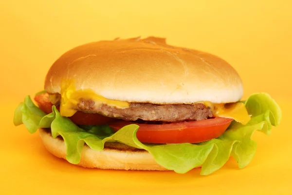 Tasty cheeseburger on yellow background — Stock Photo, Image