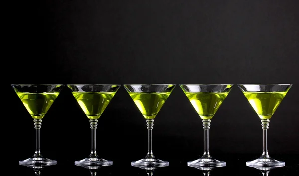 Coquetel amarelo em copos de martini isolados em preto — Fotografia de Stock