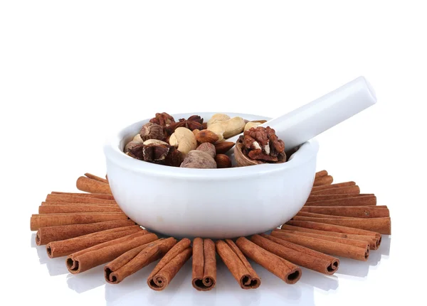 Composition of mortar with nuts and cinnamon isolated on white — Stock Photo, Image