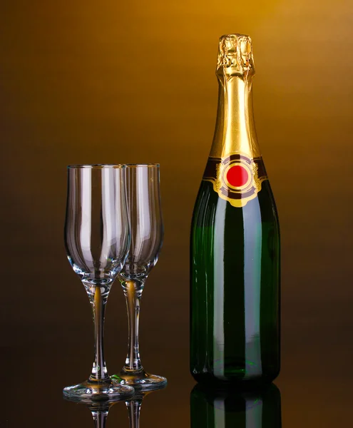 Bir şişe şampanya ve kadehler kahverengi zemin üzerinde — Stok fotoğraf
