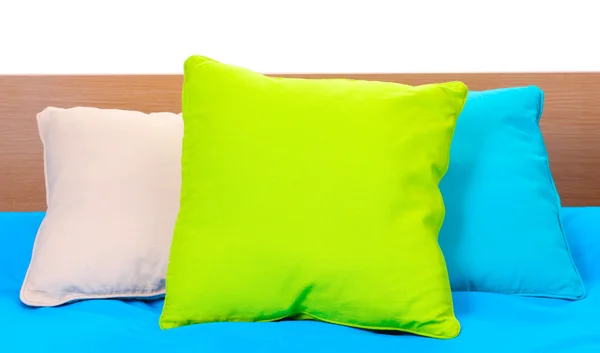 Cuscini luminosi sul letto su sfondo bianco — Foto Stock