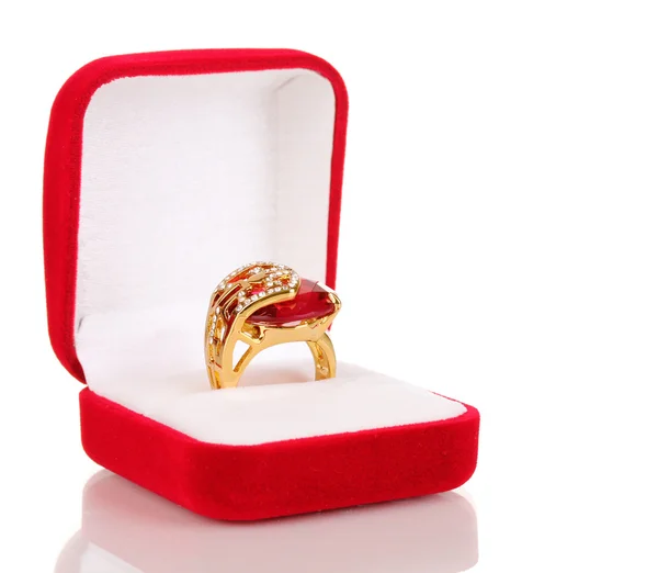 Золотое кольцо с большим красным драгоценным камнем и прозрачные кристаллы в красной бархатной коробке изолированы на белом — стоковое фото