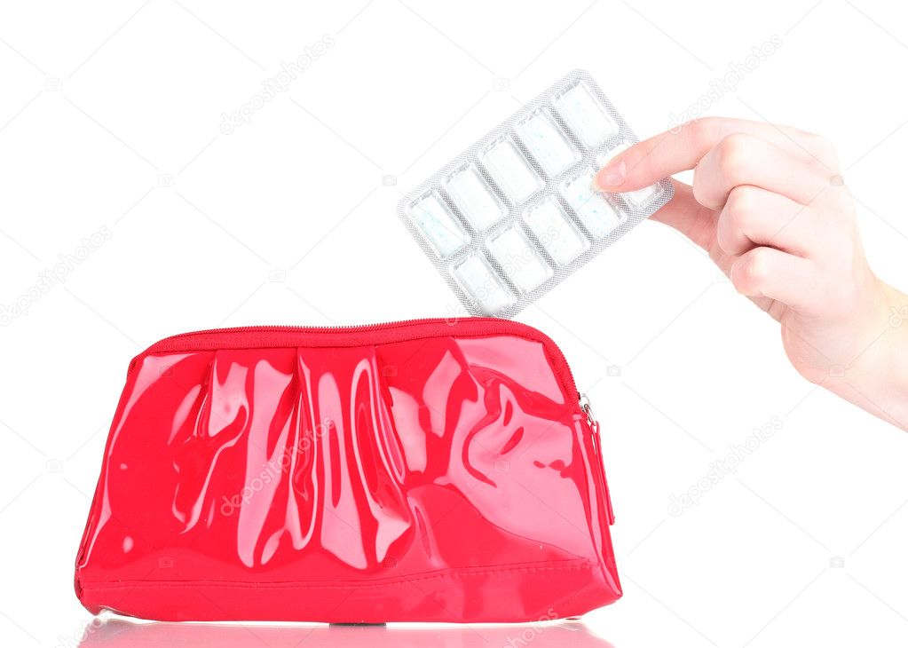 Chewing gums wrapped in golden foil in hand and cosmetic bag isolated on white