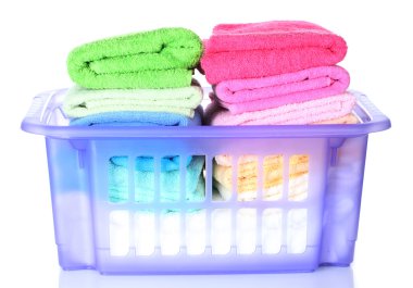 Plastic basket with bright towels isolated on white clipart