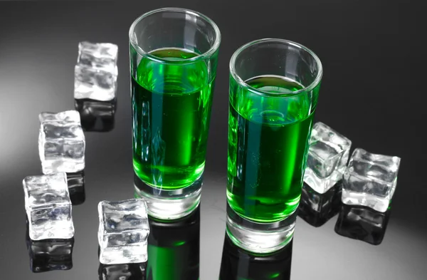 Two glasses of absinthe and ice on grey background — Stock Photo, Image