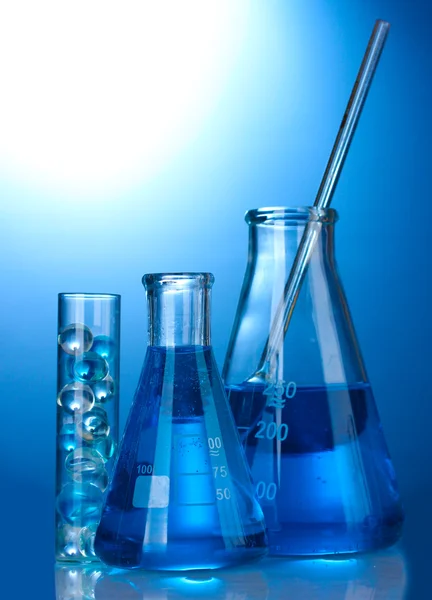 Test-tubes with blue liquid on blue background — Stock Photo, Image