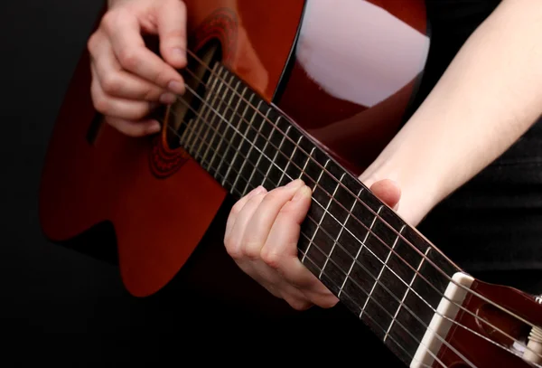 Guitarra em mãos isoladas em preto — Fotografia de Stock