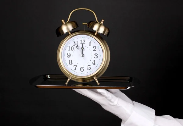 Guante de mano con bandeja de plata con despertador aislado en negro —  Fotos de Stock