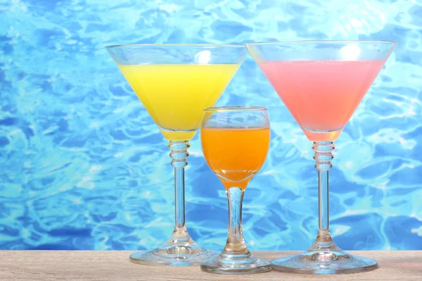 Exotic cocktails on table on blue sea background — Stock Photo, Image
