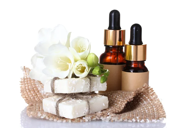 Botellas con aceite esencial, jabón y flor aislados en blanco —  Fotos de Stock