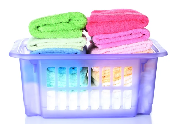 Cesta de plástico con toallas brillantes aisladas en blanco — Foto de Stock