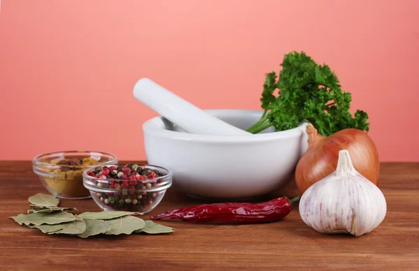 Composition of White mortar and pestle with spice and vegetables on red background — Stock Photo, Image