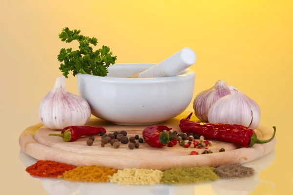 Composition of White mortar and pestle with spice and vegetables on cutting board isolated on bright background — Stock Photo, Image