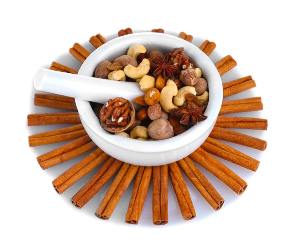 Composition of mortar with nuts and cinnamon isolated on white — Stock Photo, Image