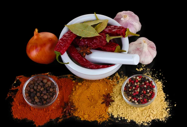 Composition of White mortar and pestle with spice and vegetables isolated on black — Stock Photo, Image