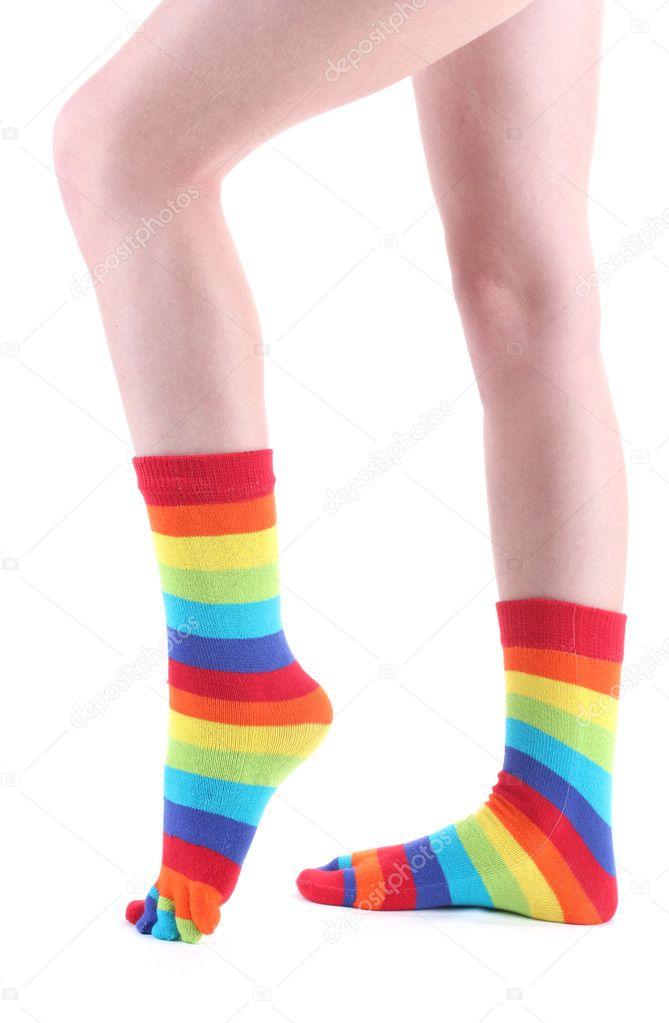 Female legs in colorful striped socks isolated on white